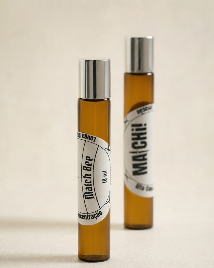 dois frascos de perfume de bolsa feitos com vidro âmbar e com tampas prateadas com rótulos brancos match bee e matchii posicionados lado a lado
