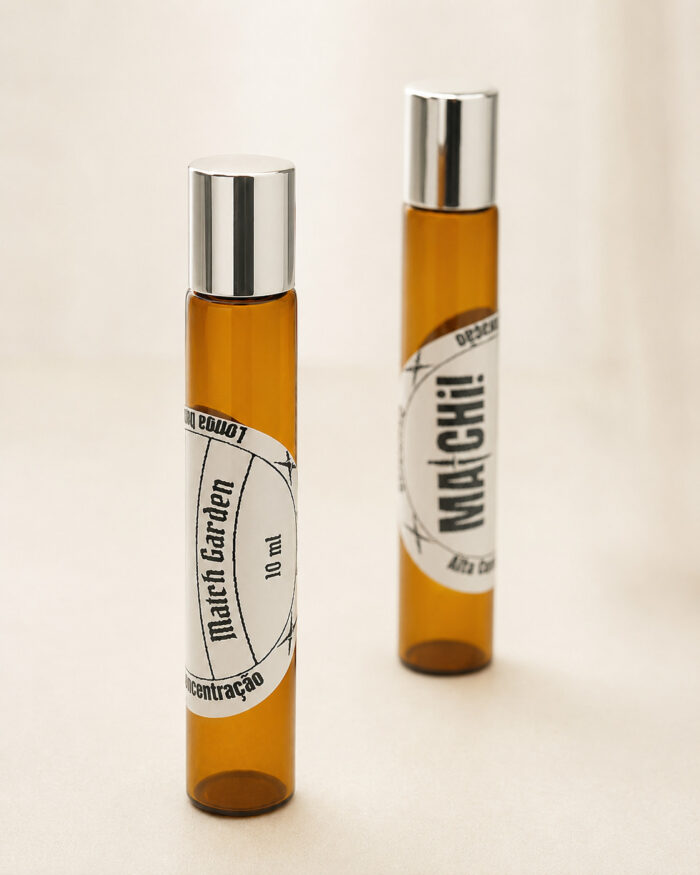 dois frascos cilíndricos de perfume de bolsa feitos de vidro âmbar com tampas cromadas com rótulos brancos match garden e matchii posicionados lado a lado