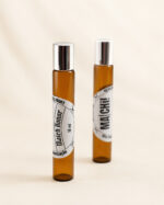 dois frascos âmbar com tampa portátl e perfume posicionados na vertical