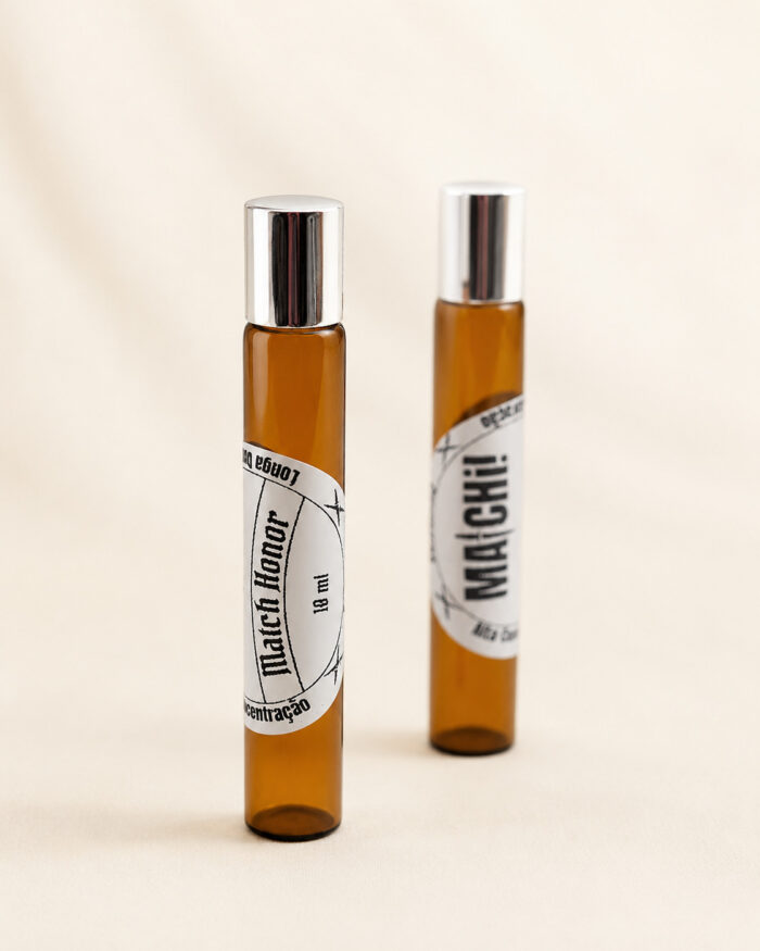 dois frascos âmbar com tampa portátl e perfume posicionados na vertical