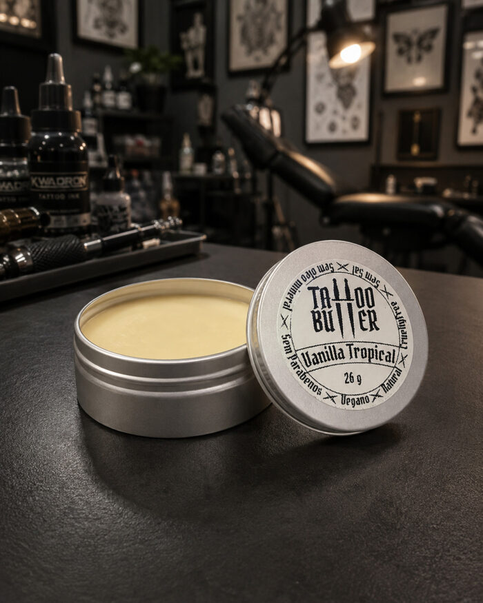 Latinha de alumínio aberta com manteiga para tatuagem com tampa com rótulo escrito matchii vanilla tropical 26 g apoiada na latinha de tatuagem sobre a mesa